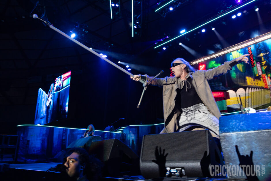 Iron Maiden's Bruce Dickinson extends his mic to the crowd, inviting them to sing along.